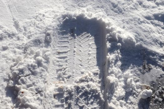 Tire Tracks on snow covered streets in a close up view