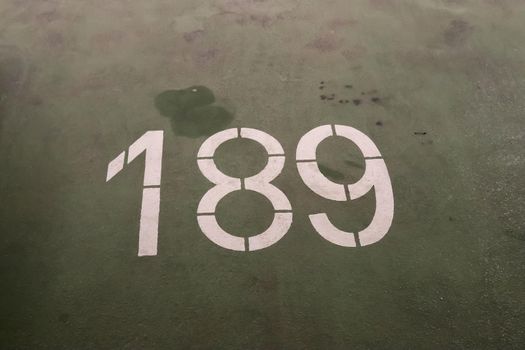 Numbers painted on concrete and asphalt textured surfaces