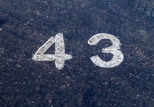 Numbers painted on concrete and asphalt textured surfaces