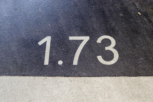 Numbers painted on concrete and asphalt textured surfaces