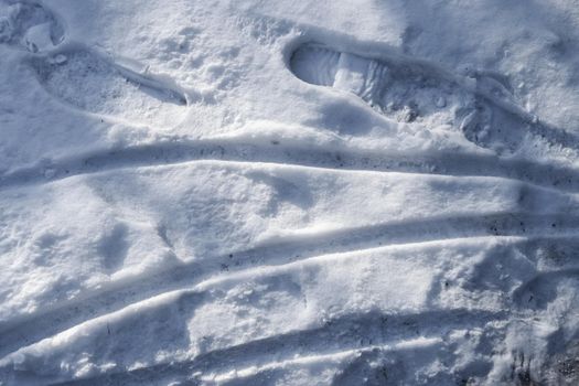 Tire Tracks on snow covered streets in a close up view