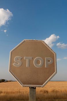 Old stop sign faded by the sun on a road in southern Spain