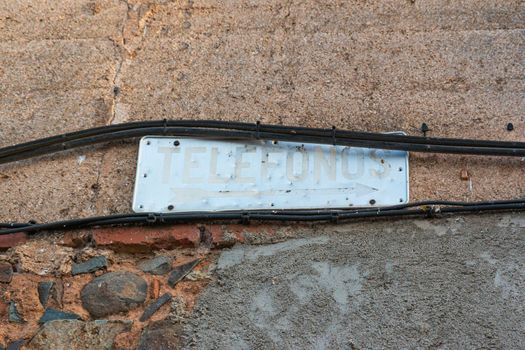 Old telephone booth sign in southern Andalusia