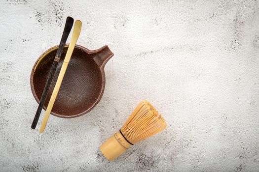 Matcha set bamboo matcha whisk and chashaku tea scoop,matcha ceramic bowl set up on white concrete background.