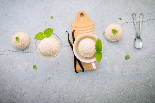 Vanilla ice cream flavor in bowl with vanilla pods setup on concrete background . Summer and Sweet menu concept.