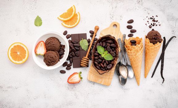 Chocolate ice cream flavours in bowl with dark chocolate and cacao nibs setup on white stone background .