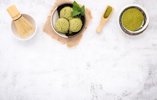 Matcha green tea ice cream with waffle cone and mint leaves  setup on white stone background . Summer and Sweet menu concept.