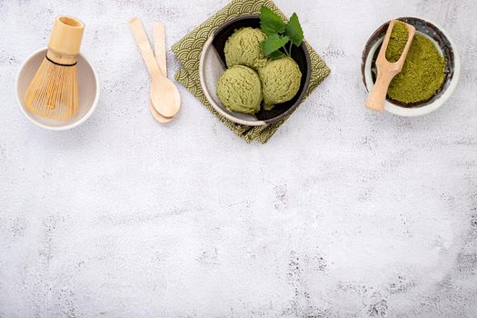 Matcha green tea ice cream with waffle cone and mint leaves  setup on white stone background . Summer and Sweet menu concept.