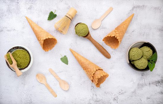 Matcha green tea ice cream with waffle cone and mint leaves  setup on white stone background . Summer and Sweet menu concept.
