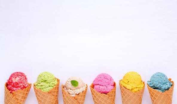 Various of ice cream flavor in cones blueberry ,strawberry ,pistachio ,almond ,orange and cherry setup on white wooden background . Summer and Sweet menu concept.