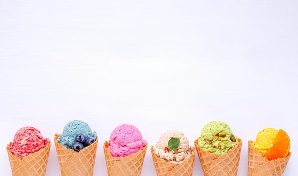 Various of ice cream flavor in cones blueberry ,strawberry ,pistachio ,almond ,orange and cherry setup on white wooden background . Summer and Sweet menu concept.