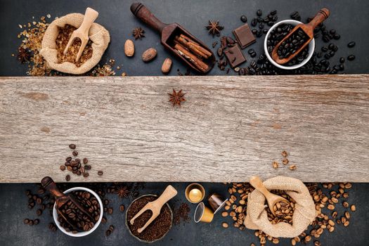 Coffee background with various of roasted coffee beans and flavourful ingredients for make tasty coffee setup on dark stone background.