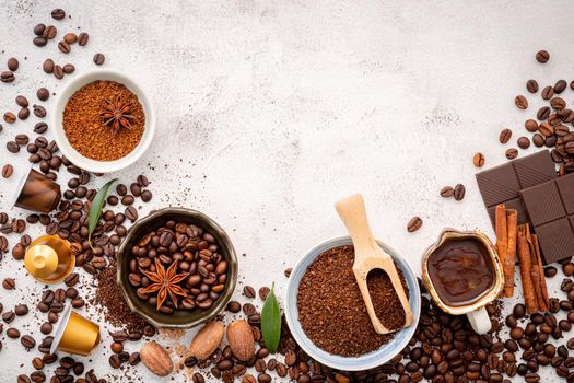 Background of various coffee , dark roasted coffee beans , ground and capsules with scoops setup on white concrete background with copy space.