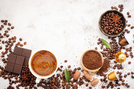 Background of various coffee , dark roasted coffee beans , ground and capsules with scoops setup on white concrete background with copy space.