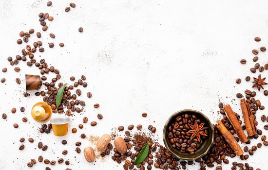 Background of various coffee , dark roasted coffee beans , ground and capsules with scoops setup on white concrete background with copy space.