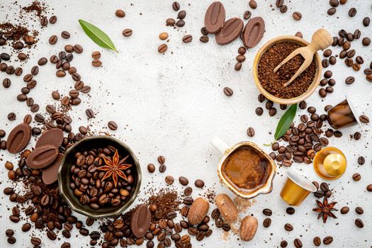 Background of various coffee , dark roasted coffee beans , ground and capsules with scoops setup on white concrete background with copy space. 