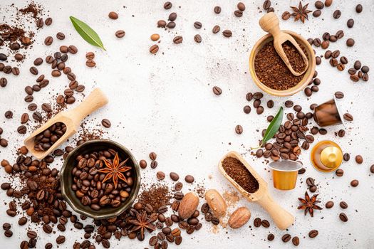 Background of various coffee , dark roasted coffee beans , ground and capsules with scoops setup on white concrete background with copy space.