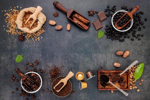 Coffee background with various of roasted coffee beans and flavourful ingredients for make tasty coffee setup on dark stone background.