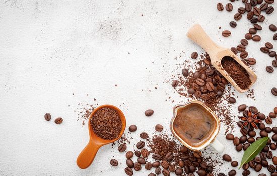 Background of various coffee , dark roasted coffee beans , ground and capsules with scoops setup on white concrete background with copy space.