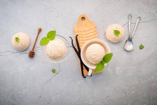 Vanilla ice cream flavor in bowl with vanilla pods setup on concrete background . Summer and Sweet menu concept.