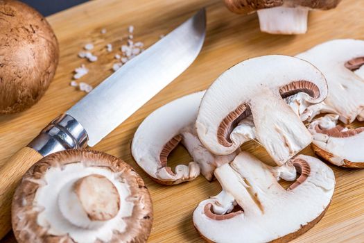 Close-up of a slice of edible mushroom Royal champignons on a cutting board. Delicious and healthy food concept.