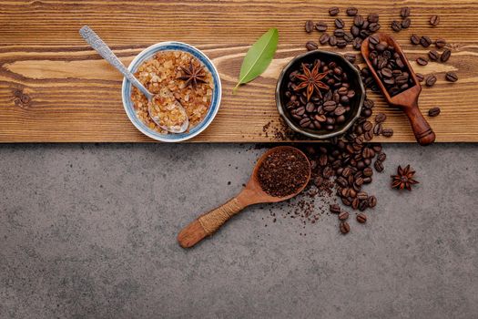 Roasted coffee beans with coffee powder setup on dark stone background.