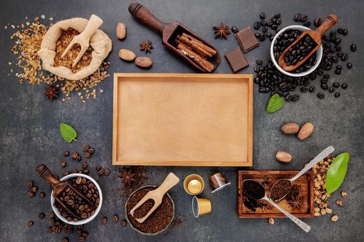 Coffee background with various of roasted coffee beans and flavourful ingredients for make tasty coffee setup on dark stone background.