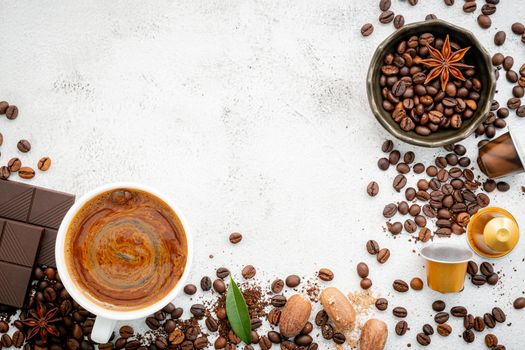 Background of various coffee , dark roasted coffee beans , ground and capsules with scoops setup on white concrete background with copy space.