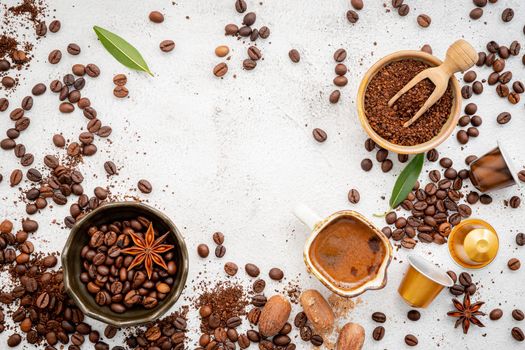 Background of various coffee , dark roasted coffee beans , ground and capsules with scoops setup on white concrete background with copy space.