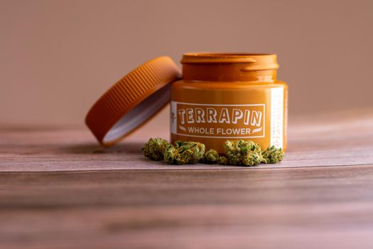 PHILADELPHIA, PA - FEBRUARY 23 2021: Devil's Lemons Medicinal Cannabis With an Orange Terrapin Whole Flower Dispensary Jar With the Lid Off Behind It