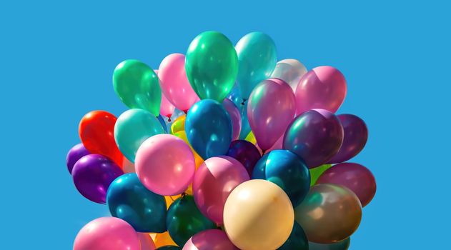 Lots of colorful balloons on the blue sky background with clouds