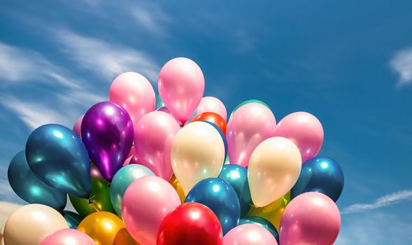Lots of colorful balloons on the blue sky background with clouds