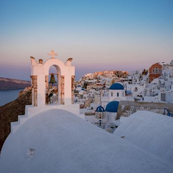 Oia village Santorini with blue domes and white washed house during sunset at the Island of Santorini Greece Europe, sunrise Santorini