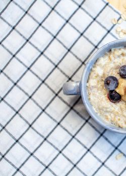 Fresh porridge with berries in a plate on a napkin. A fresh and healthy breakfast.