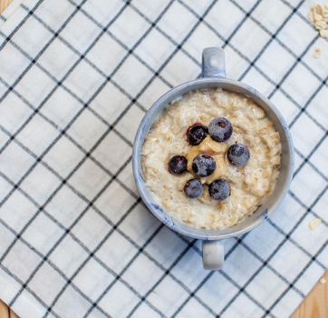Fresh porridge with berries in a plate on a napkin. A fresh and healthy breakfast.