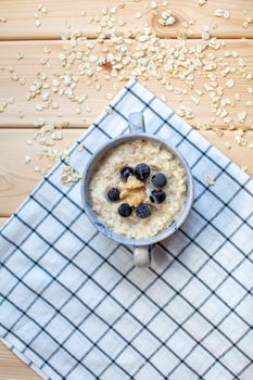 Fresh porridge with berries in a plate on a napkin. A fresh and healthy breakfast.