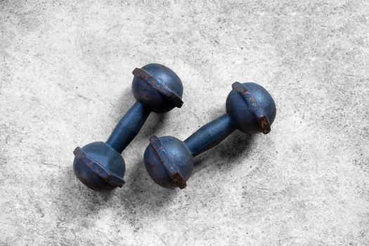 Old iron dumbbells on cement floor. Top view