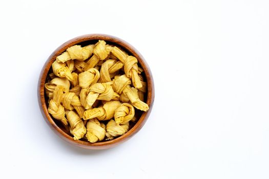 Dried bean curd knot in wooden bowl on white background. Copy space