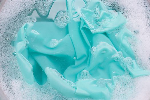 Color clothes soak in powder detergent water dissolution. Laundry concept