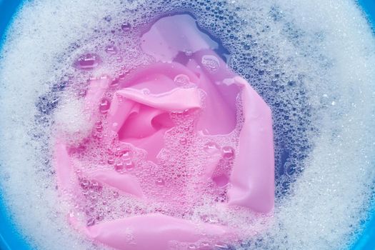 Color clothes soak in powder detergent water dissolution. Laundry concept