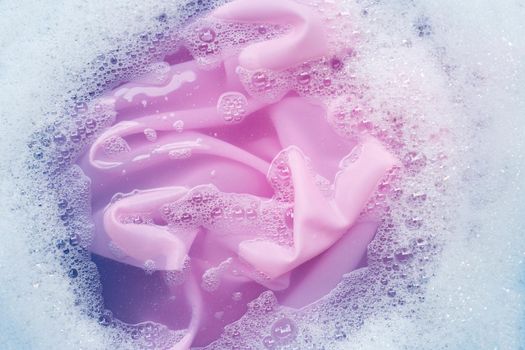 Color clothes soak in powder detergent water dissolution. Laundry concept