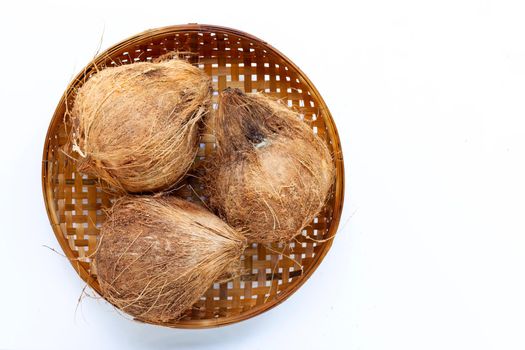 Coconut on wooden bamboo threshing basket on white background.