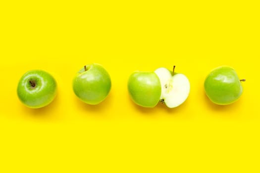 Green apples on yellow background. Top view