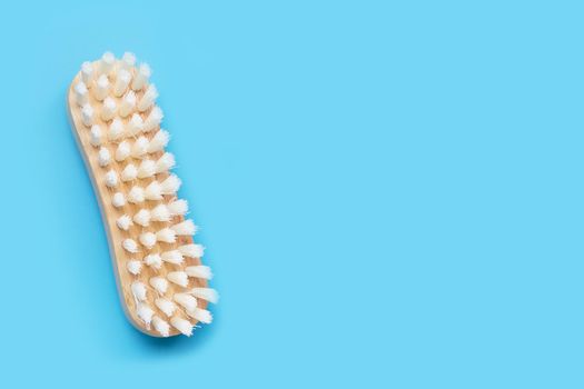 Wooden clothes brush on blue background. Top view