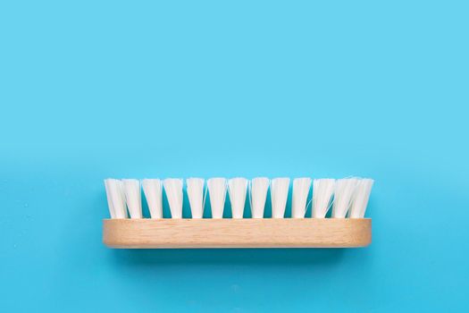 Wooden clothes brush on blue background.