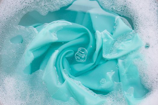 Color clothes soak in powder detergent water dissolution. Laundry concept