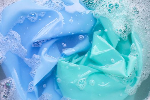 Color clothes soak in powder detergent water dissolution. Laundry concept