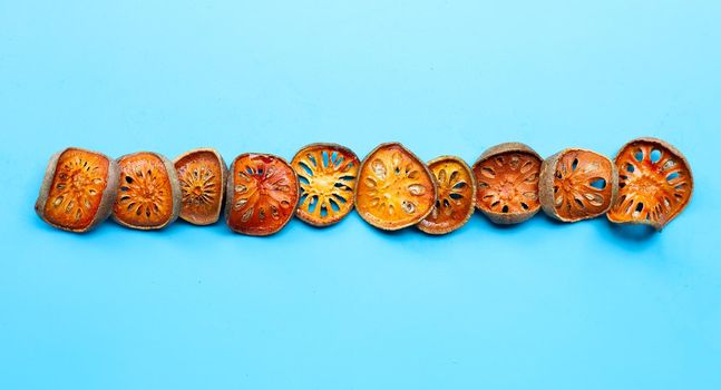 Dried bael fruit on blue background. Top view