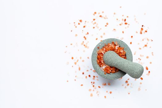 Pink himalayan salt in  stone mortar with pestle on wihte