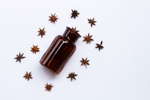 Star anis with essential oil bottle on white 